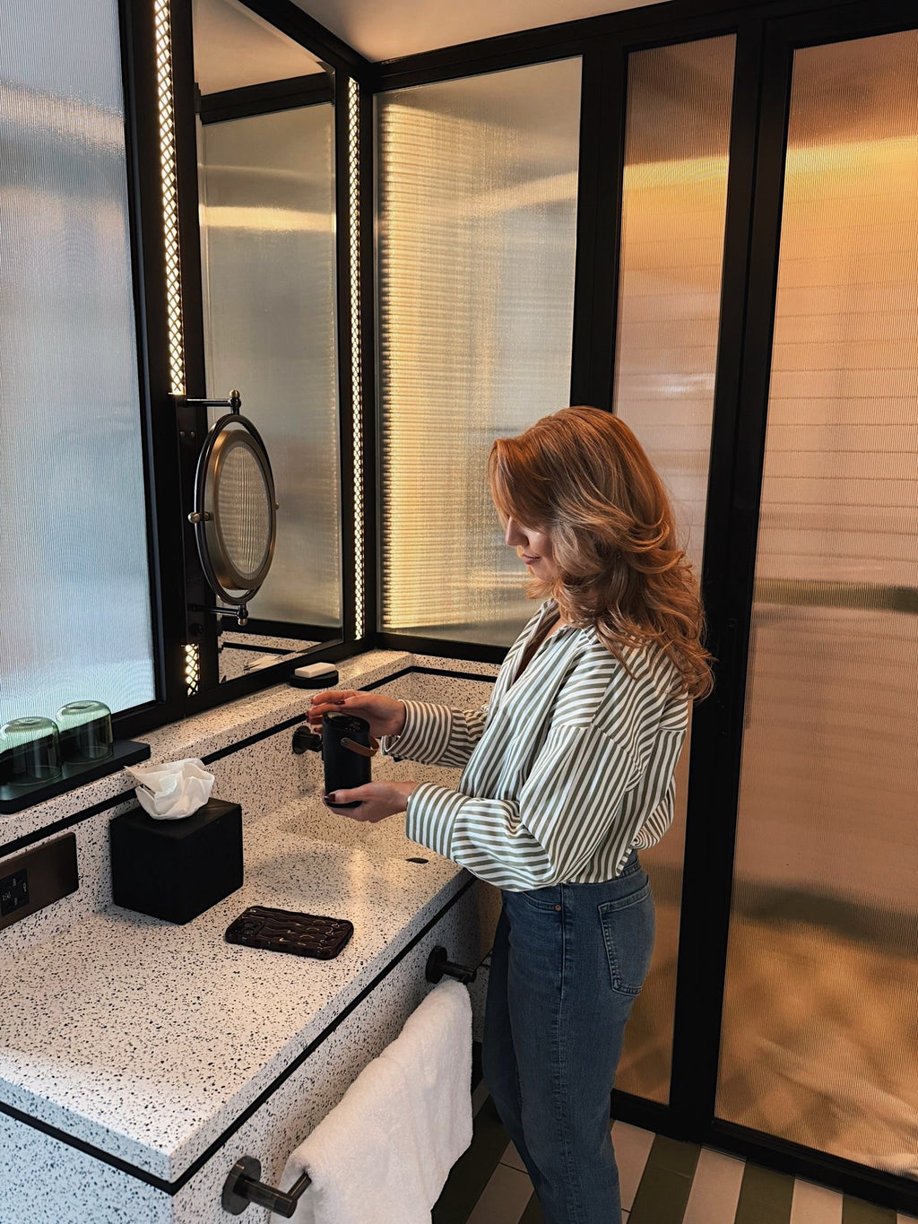 The modern hedonist founder using the waterless, portable diffuser while getting ready. everyday rituals made easy